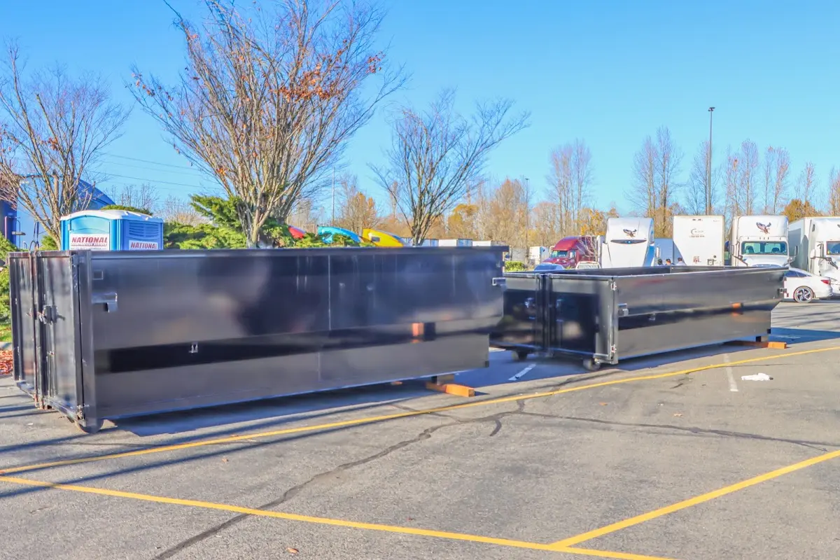 Professional dumpster rental service with roll-off container on residential driveway in Kirkwood